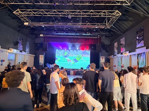 La salle, debout devant le grand écran pendant un match de l'équipe de France